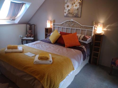 a bedroom with a large bed with towels on it at cwmddol fawr cottage in Carmarthen