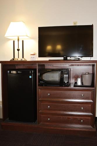 a microwave on a wooden entertainment center with a television at Bowen Motel in Moab