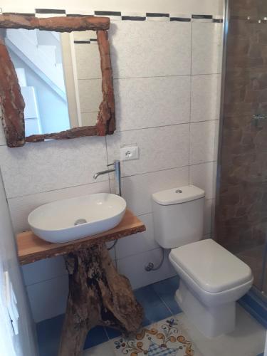 a bathroom with a sink and a toilet and a mirror at casa vacanza ginevra in Marzamemi