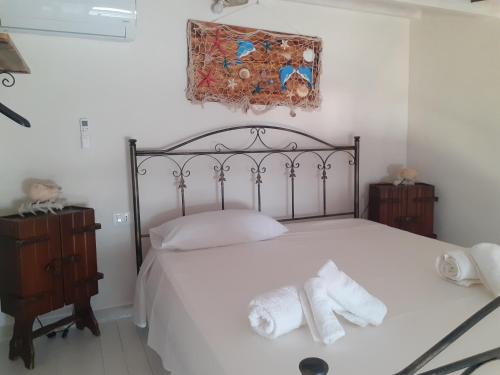 a bedroom with a white bed with towels on it at casa vacanza ginevra in Marzamemi