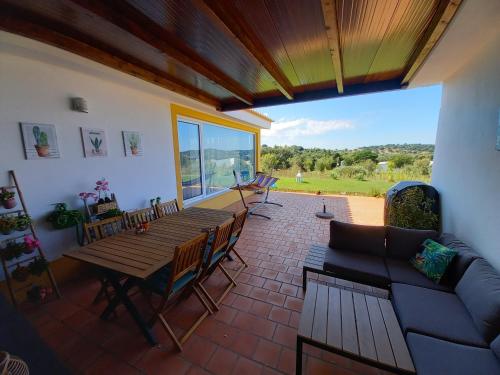 a patio with a wooden table and chairs and a couch at Casa dos Sobreiros in Cuba