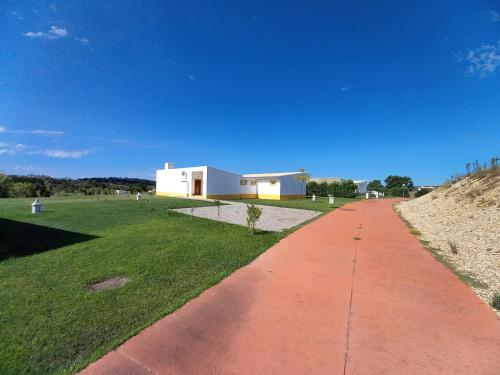 a red brick path leading to a white building at Casa dos Sobreiros in Cuba