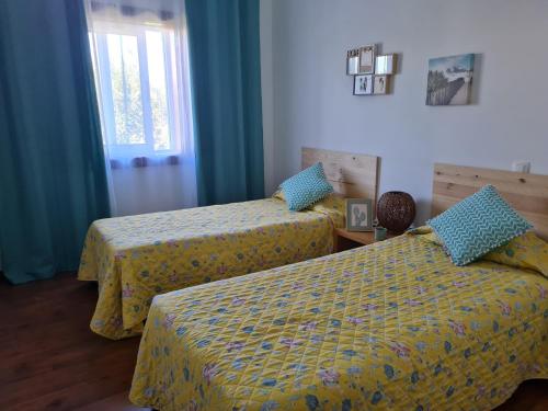 a hotel room with two beds and a window at Casa dos Sobreiros in Cuba