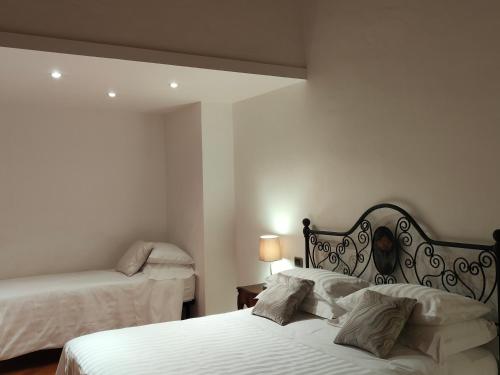 a bedroom with two beds with white sheets at B&B Villa Letizia in San Vito Rimini