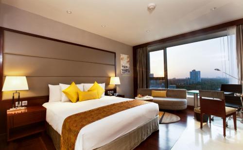 a hotel room with a bed and a large window at Crowne Plaza Kochi, an IHG Hotel in Cochin