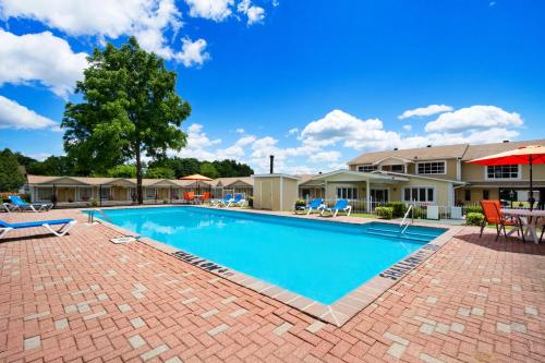a swimming pool at a resort with patio furniture at Super 8 by Wyndham Brockville in Brockville
