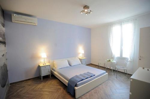 um quarto com uma cama e duas mesas e dois candeeiros em A Babordo B&B em Trapani