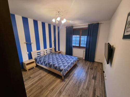 a bedroom with a bed and a television in it at Apartments Bulwar Portowy in Ustka