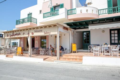 a restaurant on the side of a building with tables and chairs at Golden Bay in Agios Prokopios