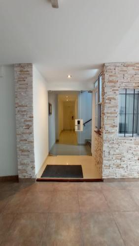 an empty hallway with a brick wall and a door at Hotel Dinastia Boutique in Salta