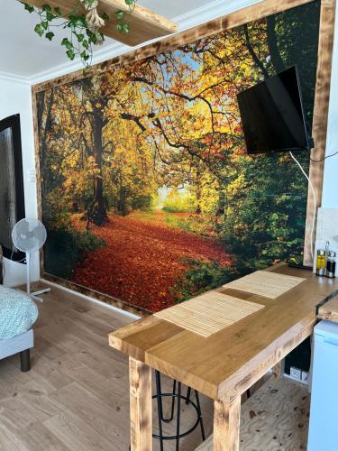 a wall mural of a forest with autumn leaves at Balade en Forêt, 3min du Zoo in Saint-Aignan