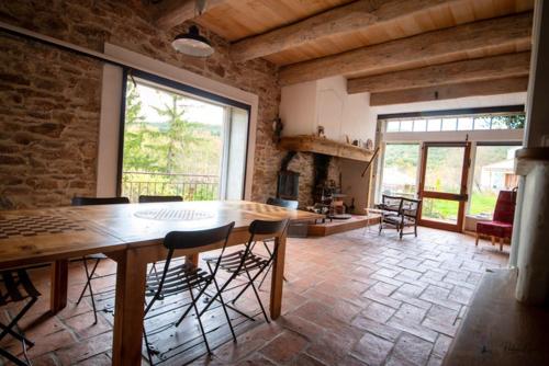 un salon avec une table et des chaises en bois dans l'établissement Maison charmante à Faugères avec vue sur la montagne, à Faugères