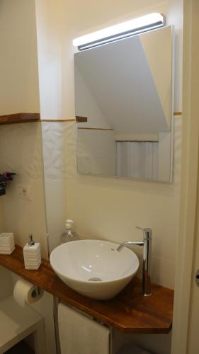 ein Badezimmer mit einem weißen Waschbecken und einem Spiegel in der Unterkunft Aura b&b in Bari