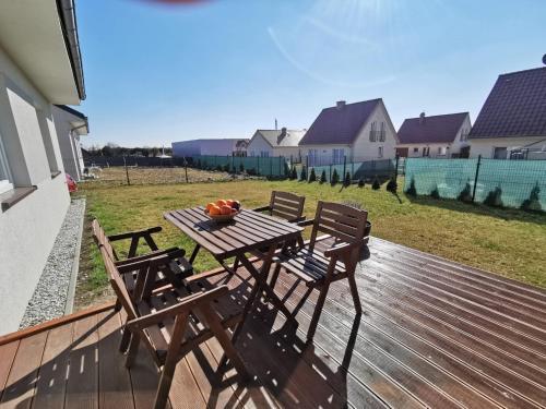 une table et des chaises en bois sur une terrasse dans l'établissement Milusi Domek, à Łagów