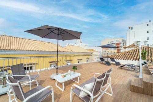 a patio with chairs and a table and an umbrella at Main Street Apartments by Raspberry Cascade in Faro