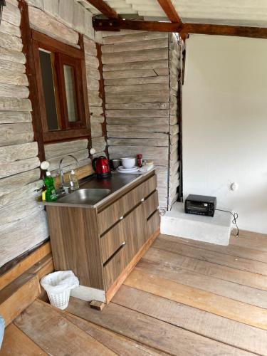 eine Küche mit einem Waschbecken in einer Holzhütte in der Unterkunft Cabañas Valle del Cocora La Truchera in Salento