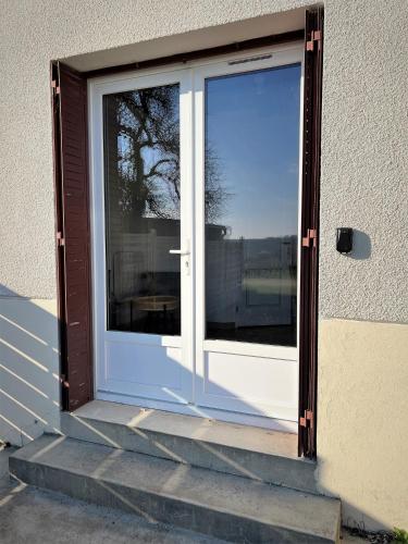 a sliding glass door with a reflection of a tree at Studio Vigneron, 3min du Zoo in Saint-Aignan