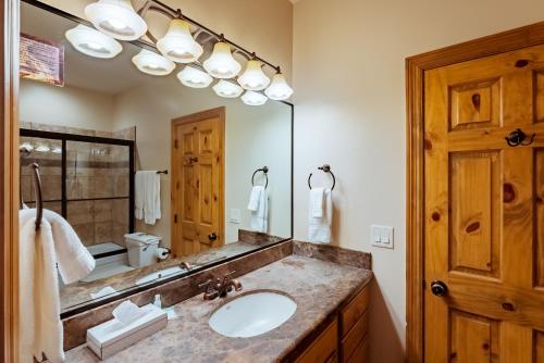 a bathroom with a sink and a large mirror at Zion Ponderosa Ranch Resort in Springdale