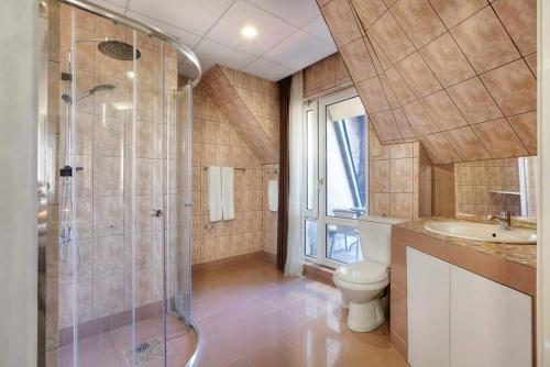 a bathroom with a shower and a toilet and a sink at HOTEL THE WHITE HOUSE Plovdiv in Plovdiv