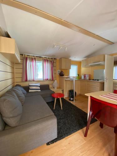 a living room with a couch and a kitchen at Le Lolipop in Capbreton