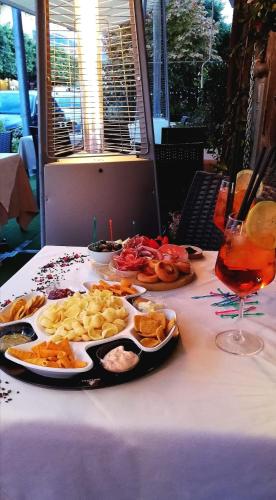 a table with a plate of food and a glass of wine at DonnaRosaHOME in Oliveri
