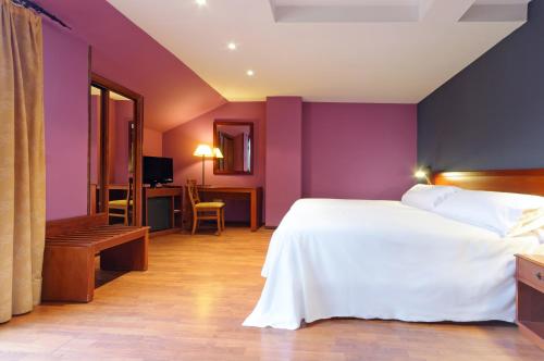 a bedroom with a white bed and purple walls at Segovia Sierra de Guadarrama in Los Ángeles de San Rafael