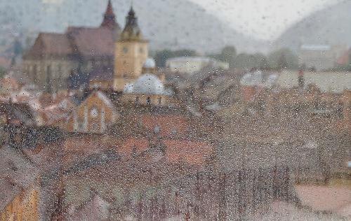 a view of a city in the rain from a window at Hotel Aro Palace in Braşov