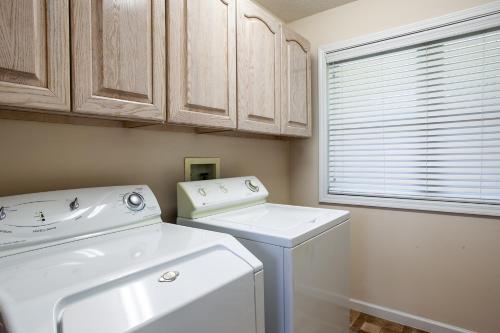 eine Waschküche mit einer Waschmaschine und einem Fenster in der Unterkunft Sunny Ridge - Hot Tub, Gym, Jacuzzi Tub, Game Room in Pigeon Forge