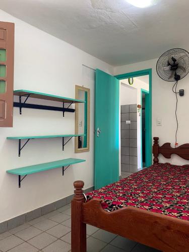 1 dormitorio con 1 cama y estanterías en la pared en Onda Colorida - Praia de Serrambi CASA 2 - VERDE, en Porto de Galinhas