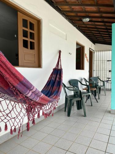 a hammock hanging on the side of a house at Onda Colorida - Praia de Serrambi CASA 2 - VERDE in Porto De Galinhas