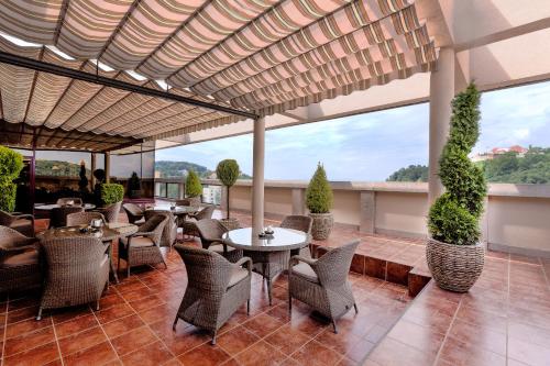 a restaurant with tables and chairs and large windows at Hotel Aro Palace in Braşov