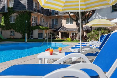 a table and chairs with umbrellas next to a pool at Villa Sedina in Rewal