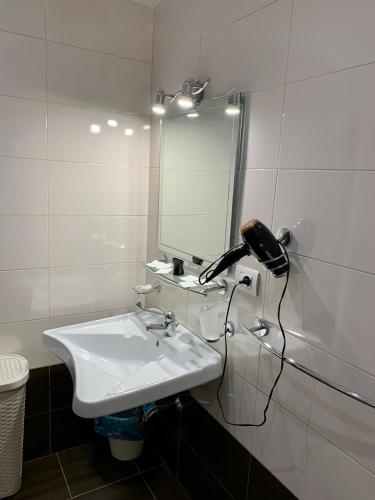 a white bathroom with a sink and a mirror at Romano B&B in Bari