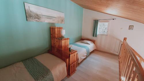 - une petite chambre avec 2 lits et un escalier dans l'établissement Maison de vacances 300 m de la mer proche forêt, à Saint-Hilaire-de-Riez