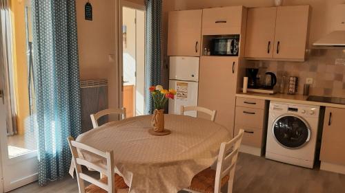 une cuisine avec une table et des chaises et une cuisine avec un lave-linge dans l'établissement Maison de vacances 300 m de la mer proche forêt, à Saint-Hilaire-de-Riez
