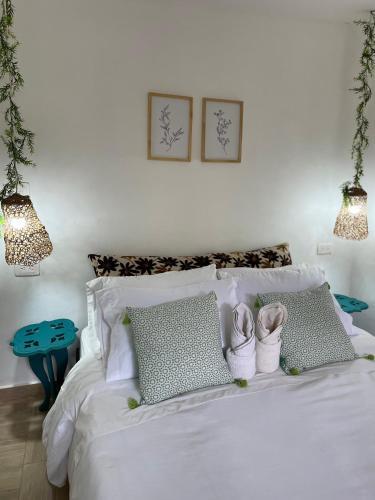 a bedroom with a bed with white sheets and pillows at Cabañas Valle del Cocora La Truchera in Salento