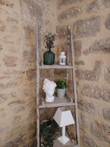 une échelle avec un vase et des fleurs sur elle dans l'établissement La Demeure du Rempart - Sarlat Centre historique, à Sarlat-la-Canéda