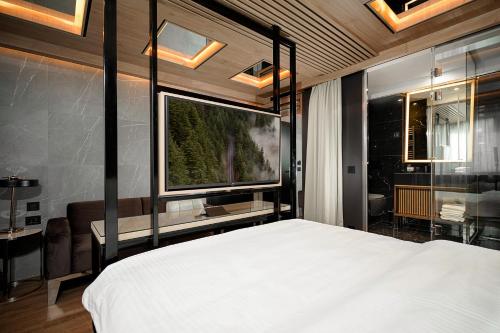 una camera con un letto e una grande TV a schermo piatto di Eden Luxury Suites Terazije a Belgrado
