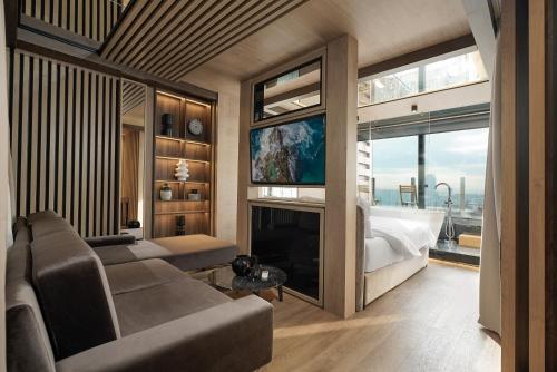 a living room with a couch and a tv and a bed at Eden Luxury Suites Terazije in Belgrade