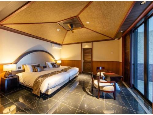 a bedroom with a large bed and a table and a desk at Miyakojima Kurima Resort Seawood Hotel - Vacation STAY 16230v in Uechi