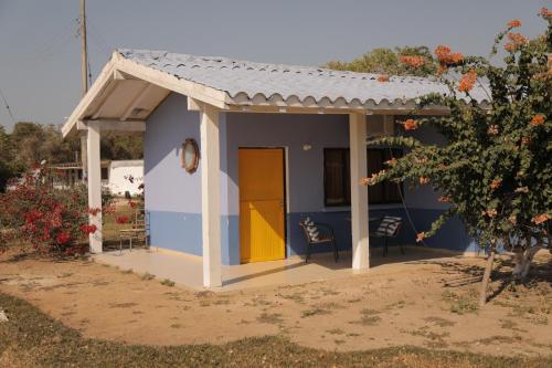 a small house with a yellow door in a yard at Club Camping Islamar in Baru