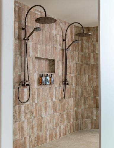 a shower with two shower heads in a bathroom at Chalets at Blackheath in Blackheath