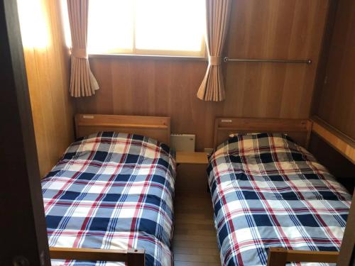 two beds in a small room with a window at Guest House Nusa - Vacation STAY 12651 in Kushiro