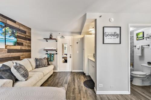 a living room with a couch and a bathroom at Inviting Waikiki Grand Hotel Room One Block to Beach! in Honolulu