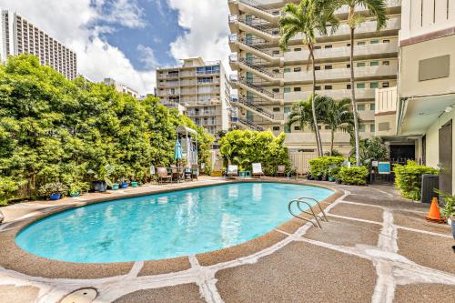 a swimming pool in an apartment with trees and buildings at Inviting Waikiki Grand Hotel Room One Block to Beach! in Honolulu