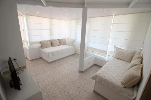 a white room with a couch and a bath tub at Olympia Hotel in Sarandë