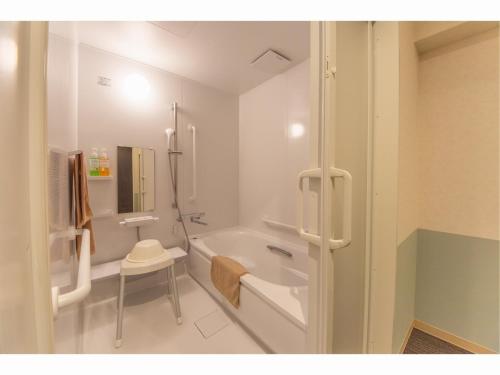 a white bathroom with a tub and a sink at Hotel Taiyonoen Tokushima Kenchomae - Vacation STAY 26340v in Tokushima