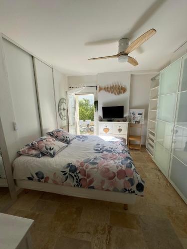 une chambre avec un lit et un ventilateur de plafond dans l'établissement RDC de maison avec terrasse barbecue, à Toulon
