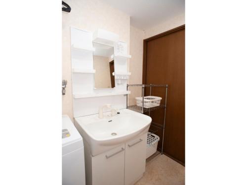 Baño blanco con lavabo y espejo en Guest House Tou - Vacation STAY 26333v en Kushiro
