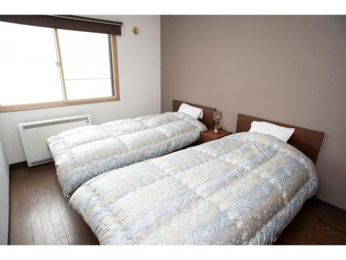 two beds sitting next to each other in a bedroom at Guest House Tou - Vacation STAY 26333v in Kushiro